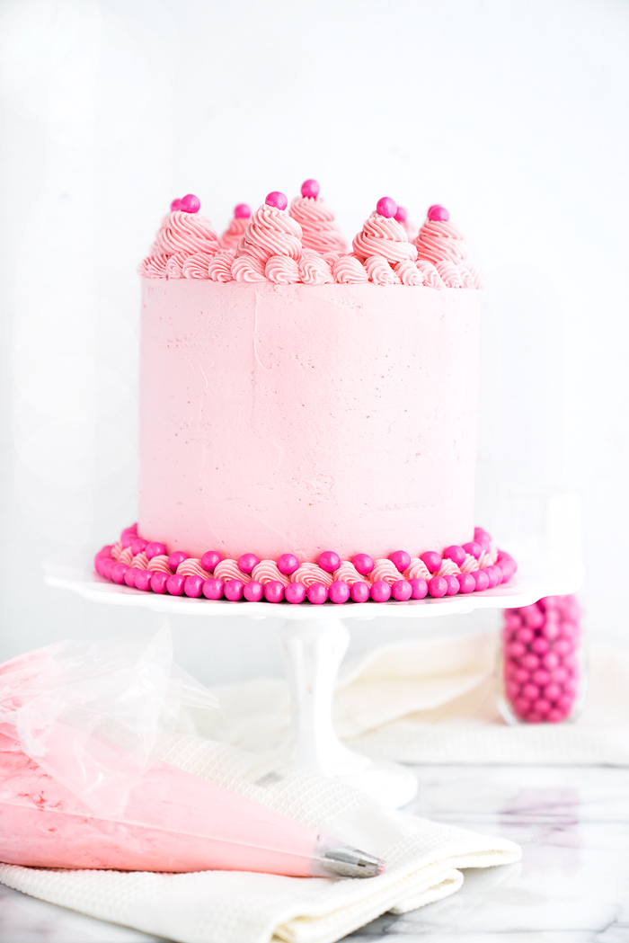 Its a Girl Baby Shower Cake Recipe! White Chocolate Cake coated in a delicate pink white chocolate swiss meringue buttercream. Pink cake, frosting, buttercream, baby shower, cake. | thesugarcoatedcottage.com