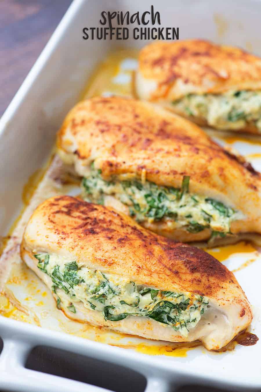 Spinach stuffed chicken breasts in white baking dish